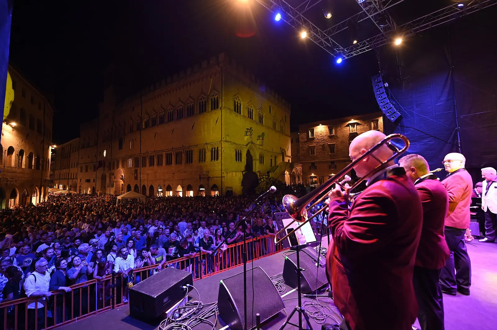 A brass band on stage before a crowd in Piazza IV Novembre in Perugia during Umbria Jazz 2023