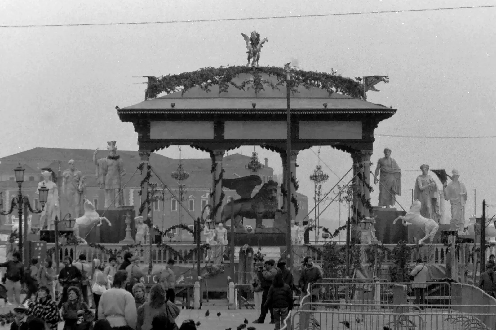 Crowds around a decorated bandstand in Venice during carnival in 1987, black and white